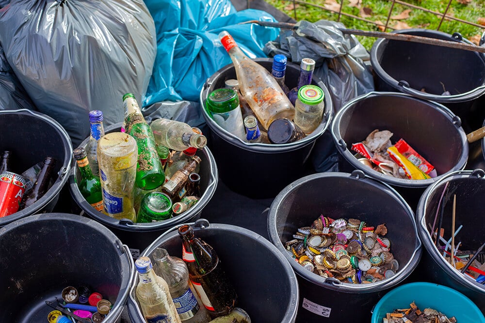 looking down inside multiple trash cans with various trash