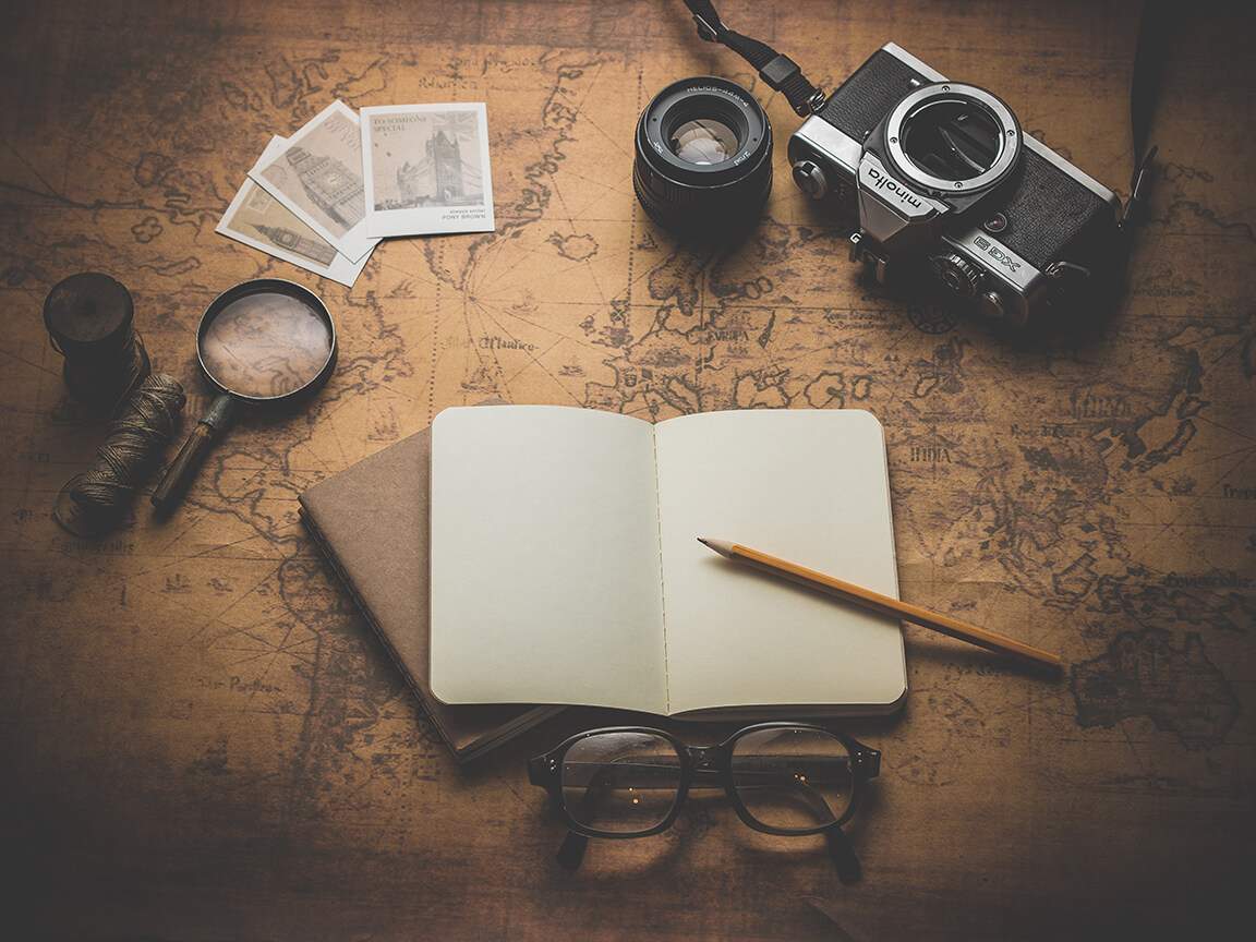 old open book with notes scattered across map